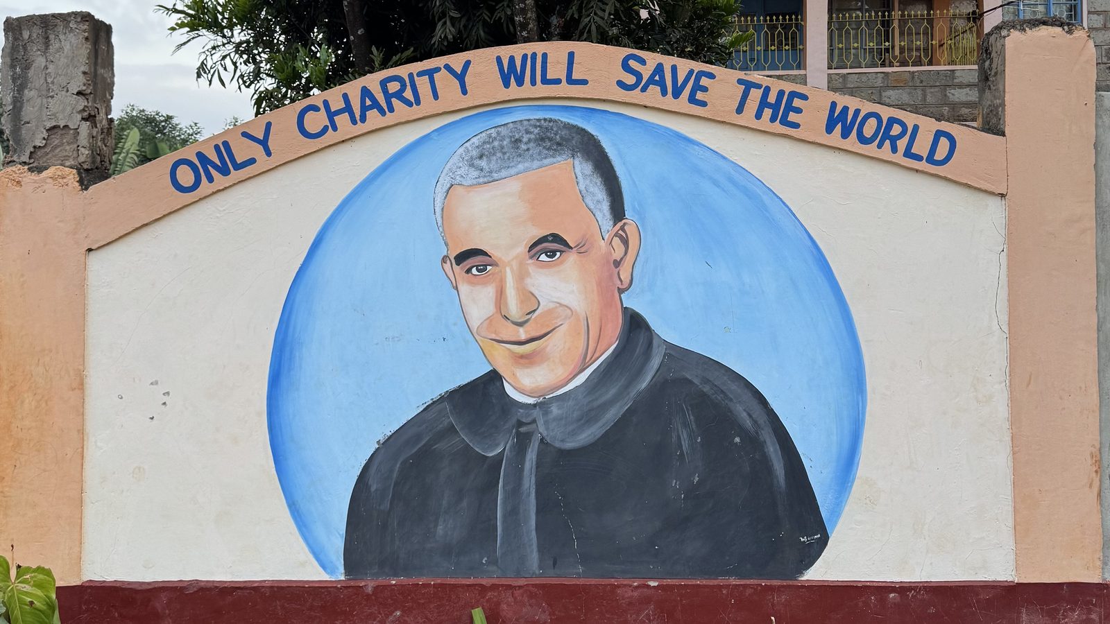 Only Charity Will Save the World — the motto of St. Luigi Orione painted at the entrance of the mission